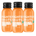 Fighter Shots vegan wellness shot with carrot, ginger, and turmeric in a 60ml glass bottle, front view.