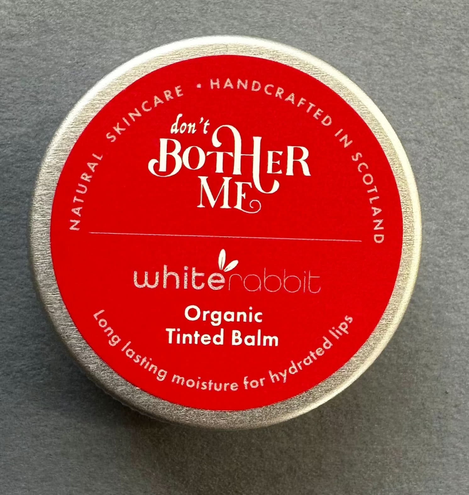 White Rabbit Skin Care Organic Tinted Lip Balm showing natural hues, smooth texture, and packaging for lips and cheeks moisturizing.