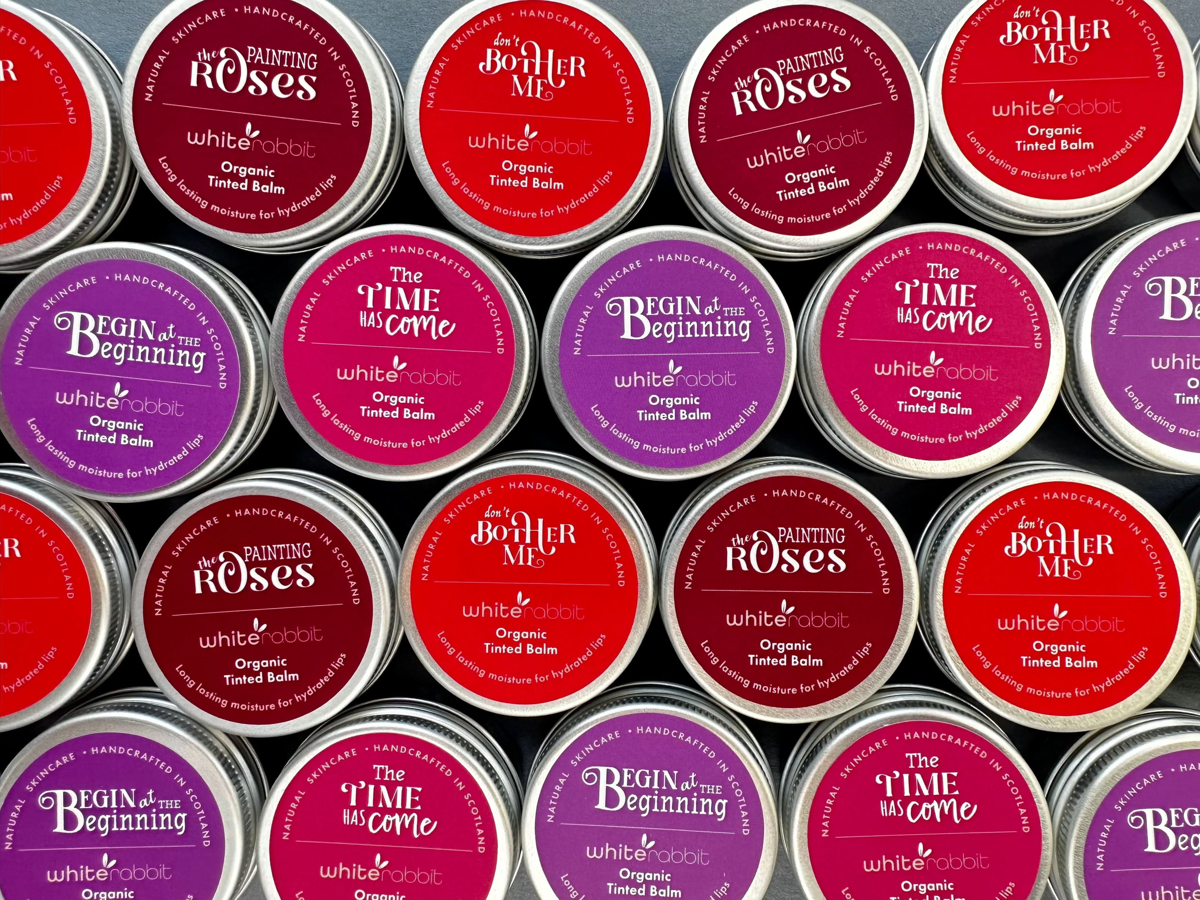 White Rabbit Skin Care Organic Tinted Lip Balm and Moisturizer showing natural pink shade on lips and cheeks.