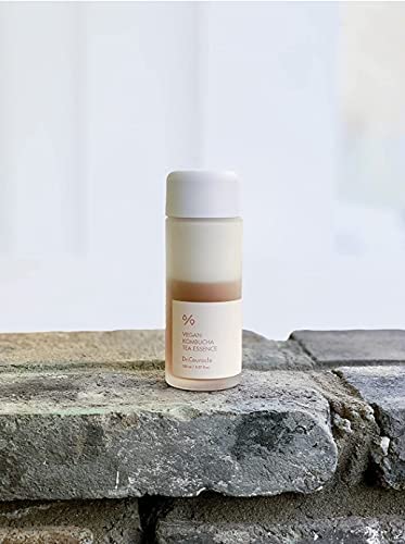 Close-up of Dr. Ceuracle Vegan Kombucha Tea Essence bottle with ingredients, highlighting natural skincare for hydration and impurity support.